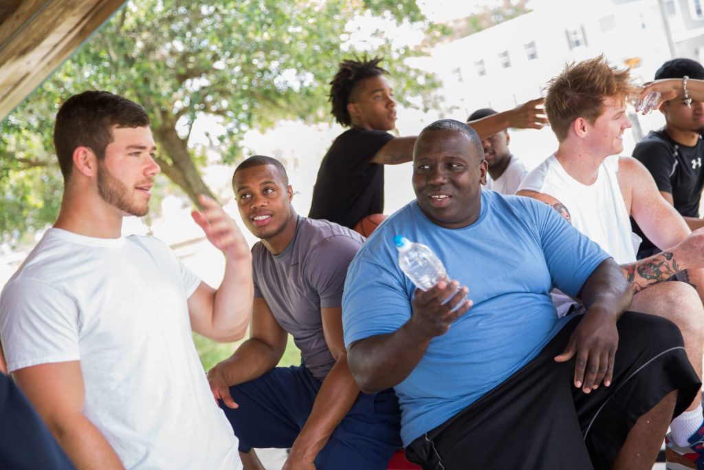 Group of young men sat outside.